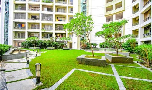 a park in front of a large apartment building at FabHotel Prime Indeedcare Hotel & Resorts - Nr Kolkata Airport in Jojera