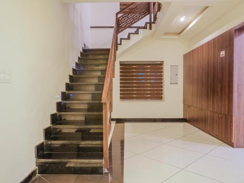 a staircase in a house with a wooden stair case at Alice Lake Promise in Alleppey