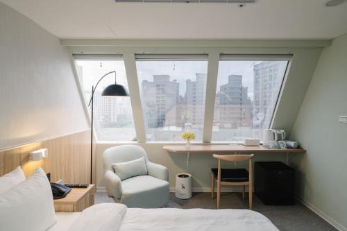 a bedroom with a bed and a chair and a desk at Hotel attic in Taipei