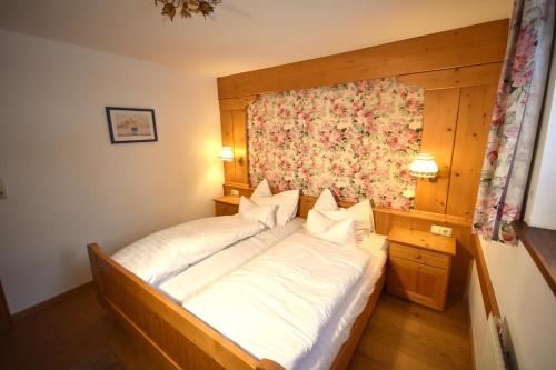 a bedroom with a large bed with white sheets at Brunnenhof Apartments in Pettneu am Arlberg