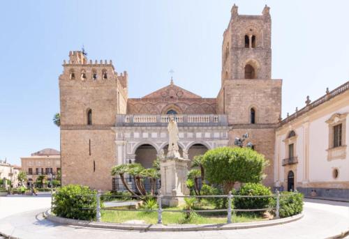 un vecchio edificio con una fontana di fronte di La casa di Angela a Monreale