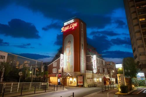 a building with a neon sign on the side of it at Roselips Tsuruhashi ローズリップス鶴橋adult only in Osaka