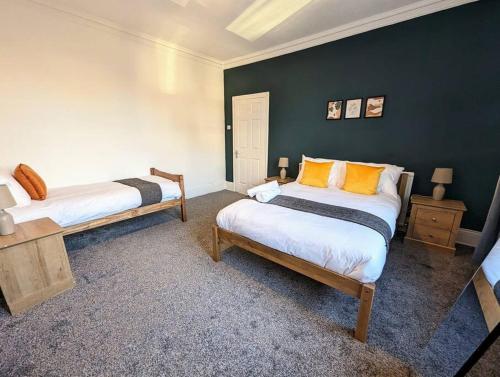 two beds in a room with green walls at Cozy stay at 3 BR close to Newcastle&Gateshead in Low Team