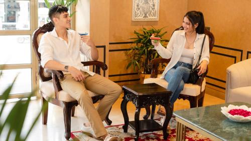 a man and a woman sitting in chairs with drinks at Hotel Bawa Udaipur in Udaipur