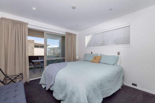 a bedroom with a bed and a large window at Cosy Alpine Retreat in Wanaka