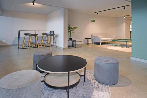 a room with a table and stools and a couch at Lux 52 Circa Apartment in Pretoria