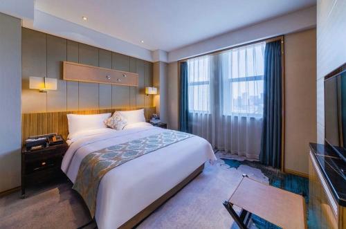 Un pat sau paturi într-o cameră la Yinchuan Xifujing Hotel