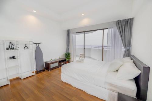 a bedroom with a white bed and a large window at Sri Sayang @ Batu Ferringhi Beach in Ayer Itam