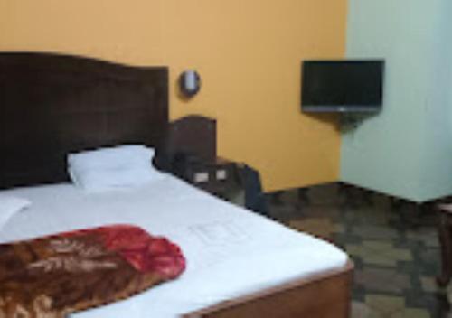 a bedroom with a bed and a flat screen tv at Hotel Solan Rourkela in Rourkela