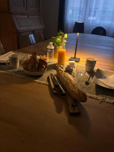 een tafel met een bord eten en een fles sinaasappelsap bij Le 8 in Mutzig