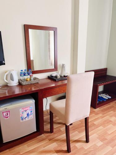 a desk with a mirror and a chair in a room at Asia Hotel Can Tho in Can Tho