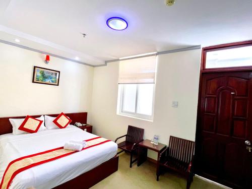 a bedroom with a bed and a table and a window at Asia Hotel Can Tho in Can Tho