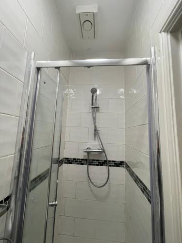 a shower in a bathroom with a glass door at Abbey Guest House in Milton Keynes