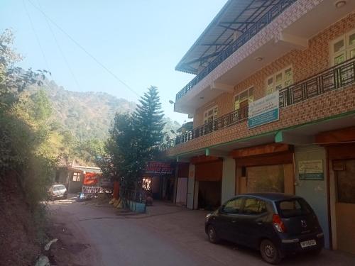 a small car parked in front of a building at Satyam home stay in Dagshai