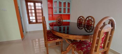 a dining room with a table and two chairs at Orange Valley Homestay Trivandrum in Trivandrum