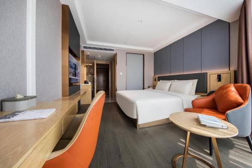 une chambre d'hôtel avec un lit, une table et des chaises dans l'établissement Atour X Hotel Shenzhen Guanlan Shanshui Pastoral, à Longhua