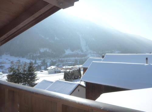 a view from a balcony of snow covered roofs at Brunnenhof Apartments in Pettneu am Arlberg
