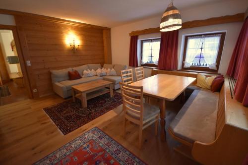 a living room with a table and a couch at Brunnenhof Apartments in Pettneu am Arlberg