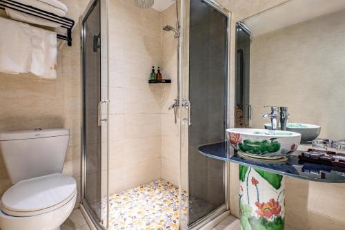 e bagno con doccia, servizi igienici e lavandino. di Tongli Lanshe Garden B&B a Suzhou