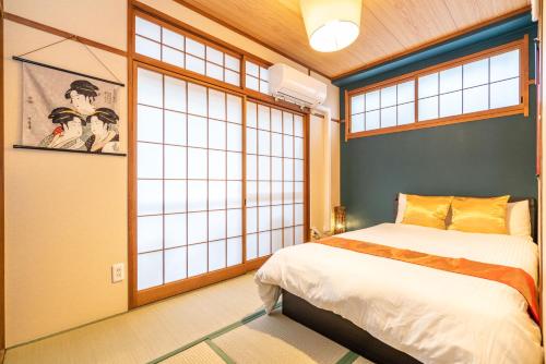 a bedroom with a bed and a large window at KYARA Hotel 白鳥 in Tokyo