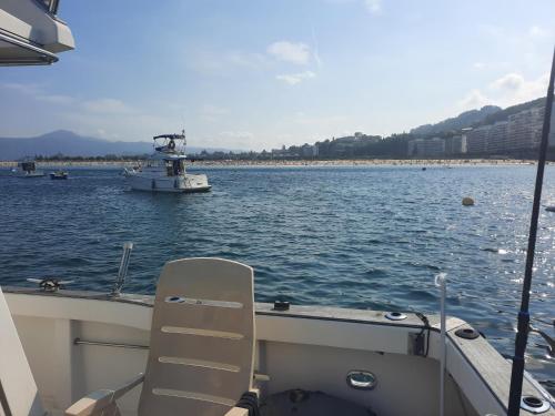 un bateau avec une chaise sur l'eau dans l'établissement Bateau à quai port hendaye, à Hendaye