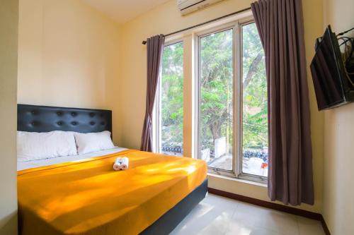 a bedroom with a bed and a large window at Athena Syariah Residence in Tangerang