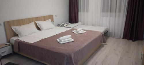 a hotel room with a bed with two towels on it at Agropensiunea DAVID SI MARIA in Niculiţel