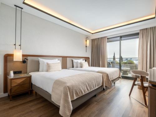 een hotelkamer met 2 bedden en een balkon bij Anda Barut Collection - Ultra All Inclusive in Didim