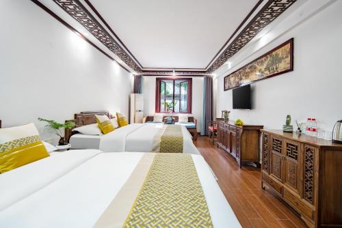 a hotel room with two beds and a television at Tongli Lanshe Garden B&B in Suzhou