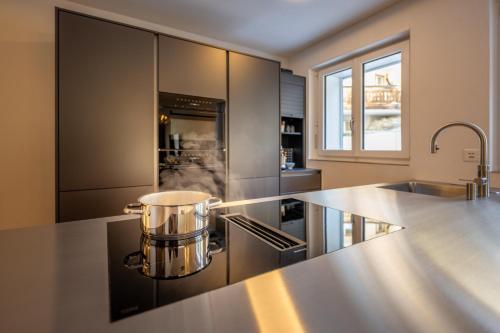 una cucina con pentola sopra un piano cottura di Seventh Sky - the luxury apartment a Zermatt