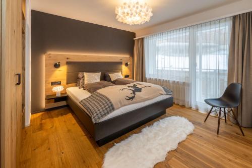 a bedroom with a large bed and a chair at Seventh Sky - the luxury apartment in Zermatt