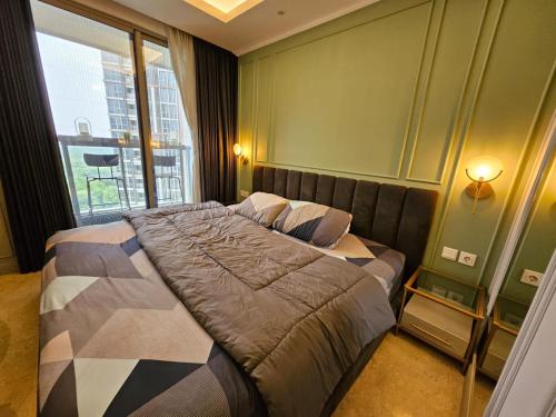 Gold Coast Apartemen PIK by Dluxx في جاكرتا: غرفة نوم بسرير ونافذة كبيرة