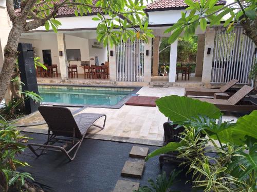 una piscina con sedie e tavoli in un cortile di Balian Paradise Resort a Selemadeg