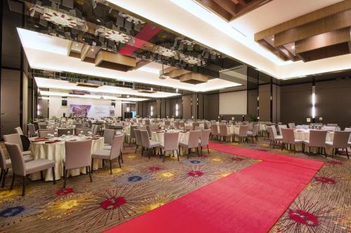 a banquet hall with white tables and chairs at Impiana Hotel Senai in Kulai