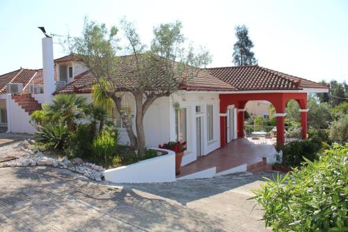 een huis met een rood dak bij Villa Daphne in Tolo
