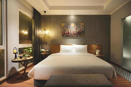 a bedroom with a large white bed and two tables at HaNoi Calido - 16 Phố Nguyễn Quang Bích HN - by BAY LUXURY in Hanoi