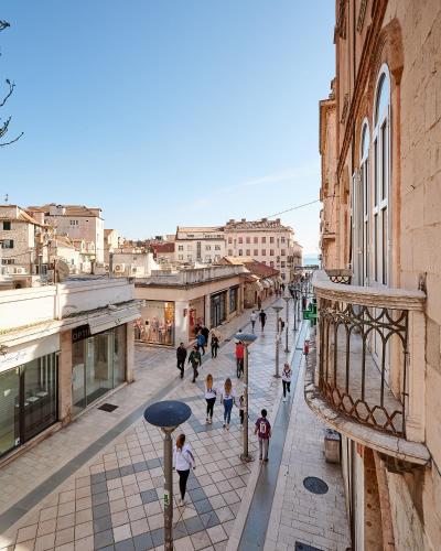 a group of people walking down a street at Marmont City Rooms in Split