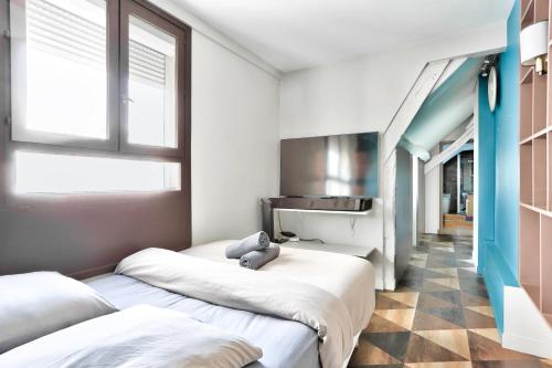 ein kleines Zimmer mit 2 Betten und einer Küche in der Unterkunft Le Marais Superb Apartment Terrace Paris in Paris