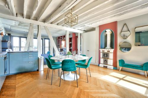 une cuisine et une salle à manger avec une table et des chaises dans l'établissement Le Marais Superb Apartment Terrace Paris Free Netflix, à Paris