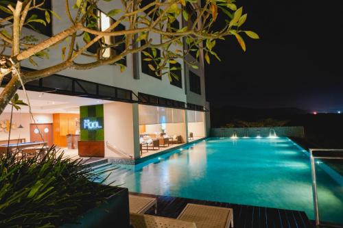 een zwembad voor een gebouw 's nachts bij Impiana Hotel Senai in Kulai