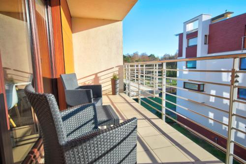 a balcony with two chairs on a building at HelApart - Foka in Hel