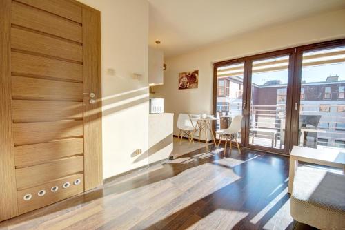 a living room with a sliding door and a table and chairs at HelApart - Foka in Hel