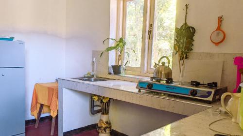 a kitchen with a stove and a sink and a window at Ella Relax Inn in Ella