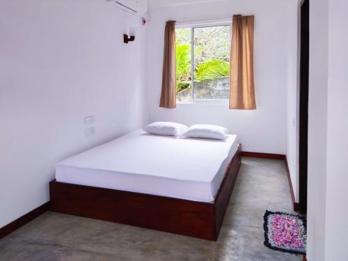 a bedroom with a bed and a window at Arazo villa in Unawatuna