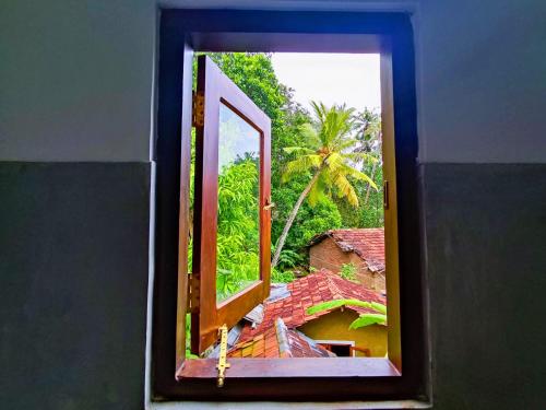 an open window with a view of a house at Arazo villa in Unawatuna