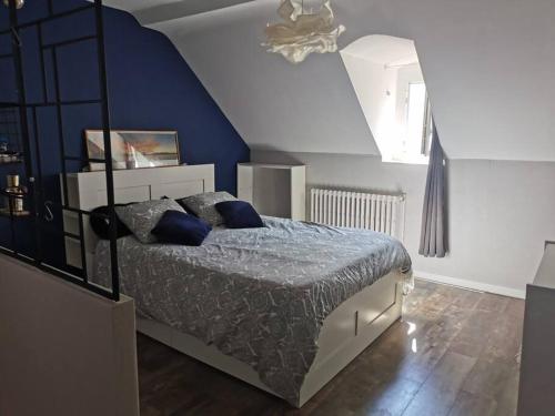a bedroom with a bed and a blue wall at Agréable maison de ville, en triplex in Blois