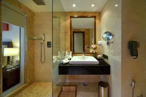 y baño con lavabo y ducha. en Golden Tulip Lucknow, en Lucknow