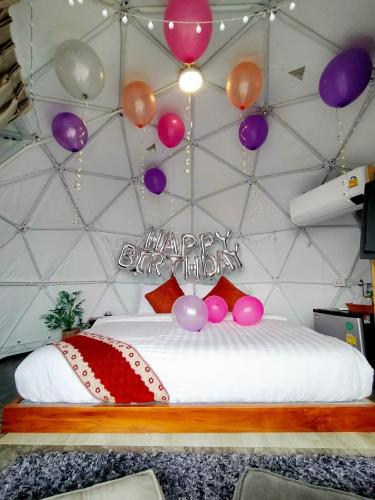 a room with a bed with balloons on the wall at Heaven Hill Camping in Ban Thung Na