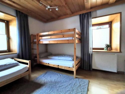 1 dormitorio con 2 literas y alfombra azul en Apart am Dorfplatz, en Kauns