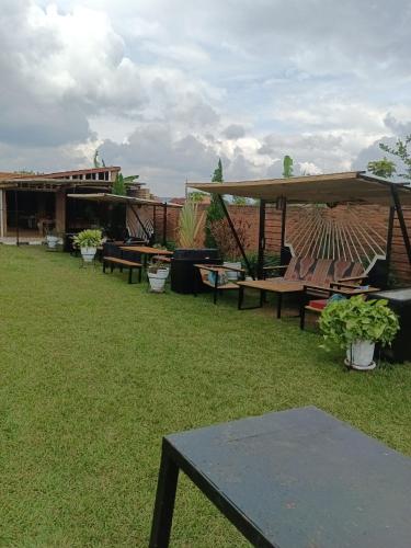 a group of tables and umbrellas in a yard at VENUS Villa BOUTIQUE HOTEL KIGALI in Kigali
